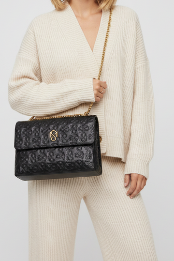 Model wearing cream outfit carrying Signature Luxe Flap Large – Black/Gold by Shanaè Monèt